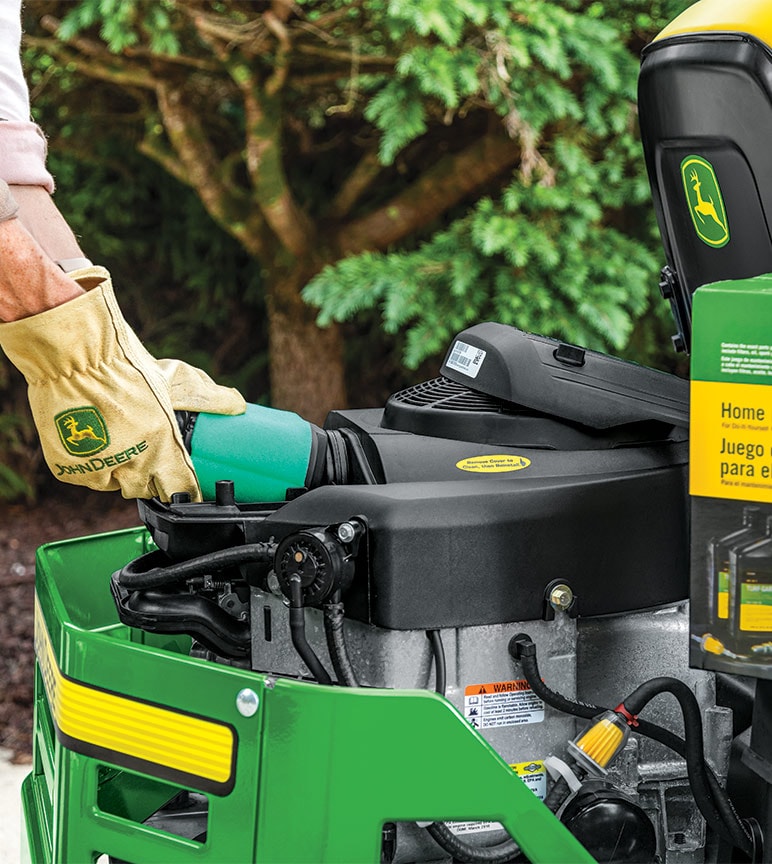 Person wearing John Deere gloves working with a home maintenance kit