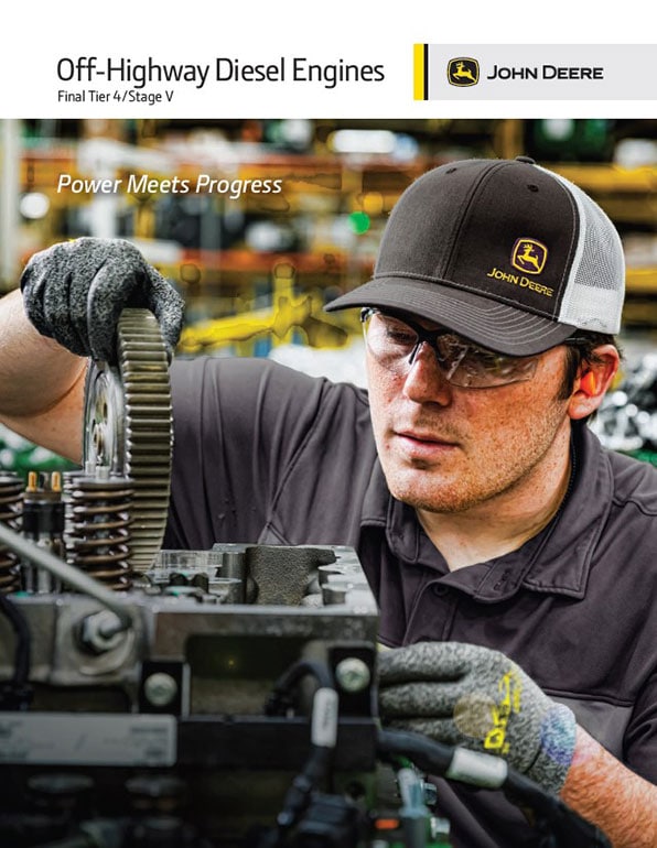 A John Deere worker wearing a hat and goggles working on a machine