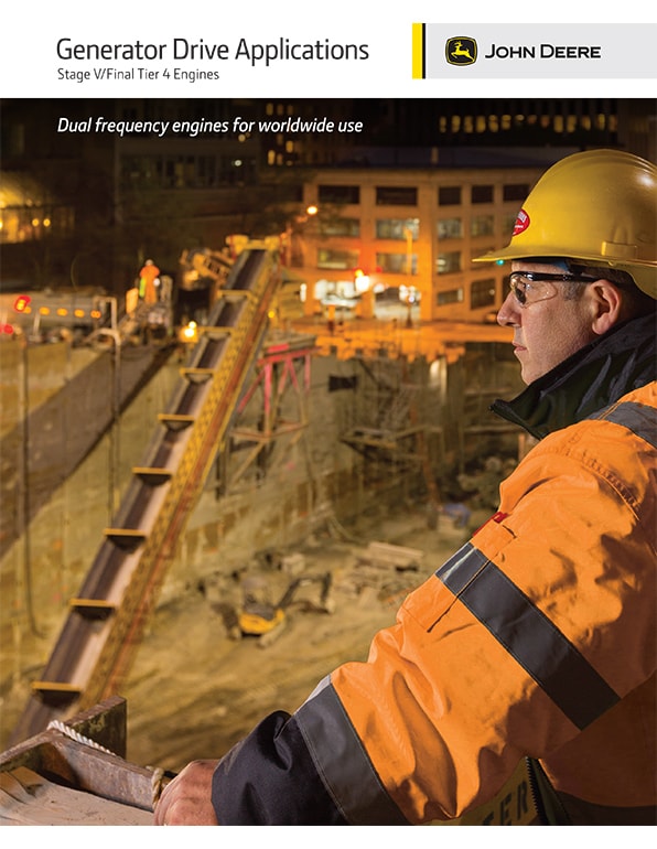 A person in a hard hat and orange jacket surveying a well lit worksite at night