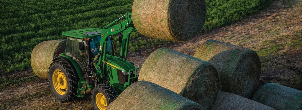 aerial view of a tractor loaded rolls of hay