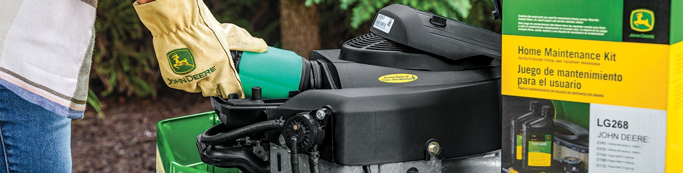 A person working on a John Deere mower using a Home Maintenance Kit