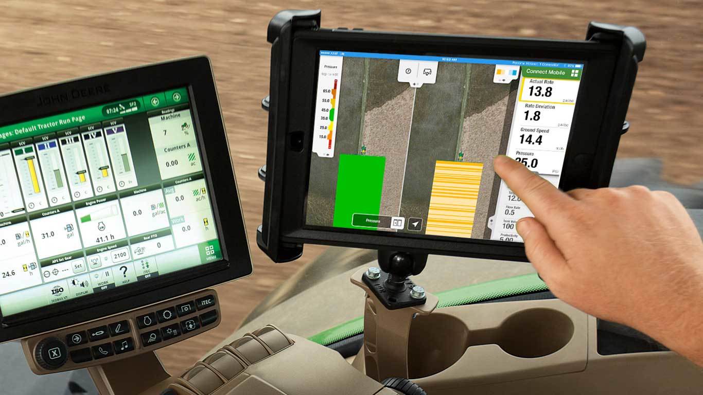 Person using John Deere digital technology in agricultural equipment